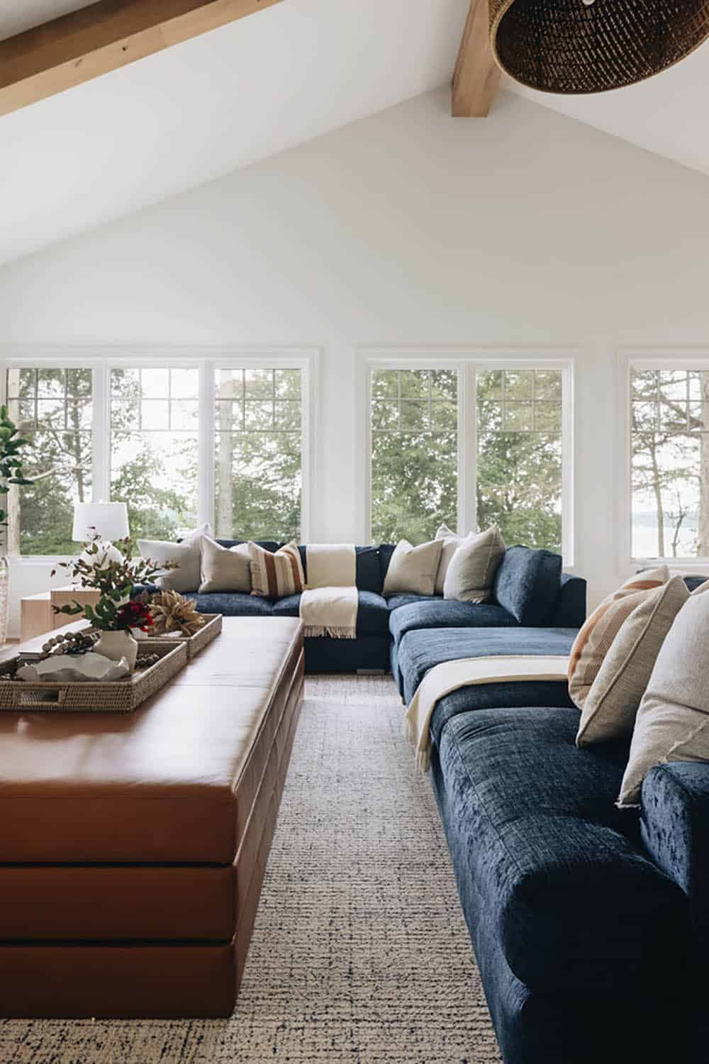 Vaulted living room with navy sectional facing wall of windows