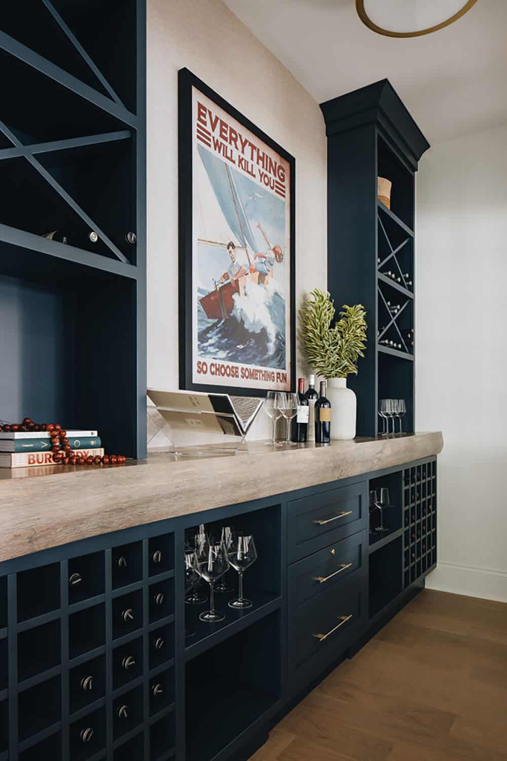 Navy built-in wine bar with sailing-themed art and wood countertop
