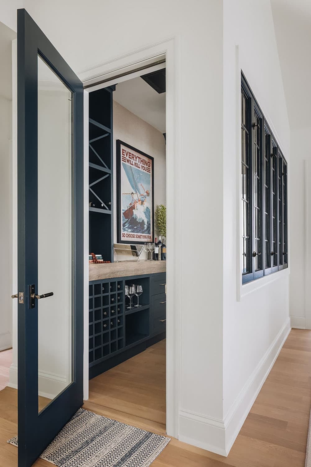 Hallway view through open door into navy wine bar room