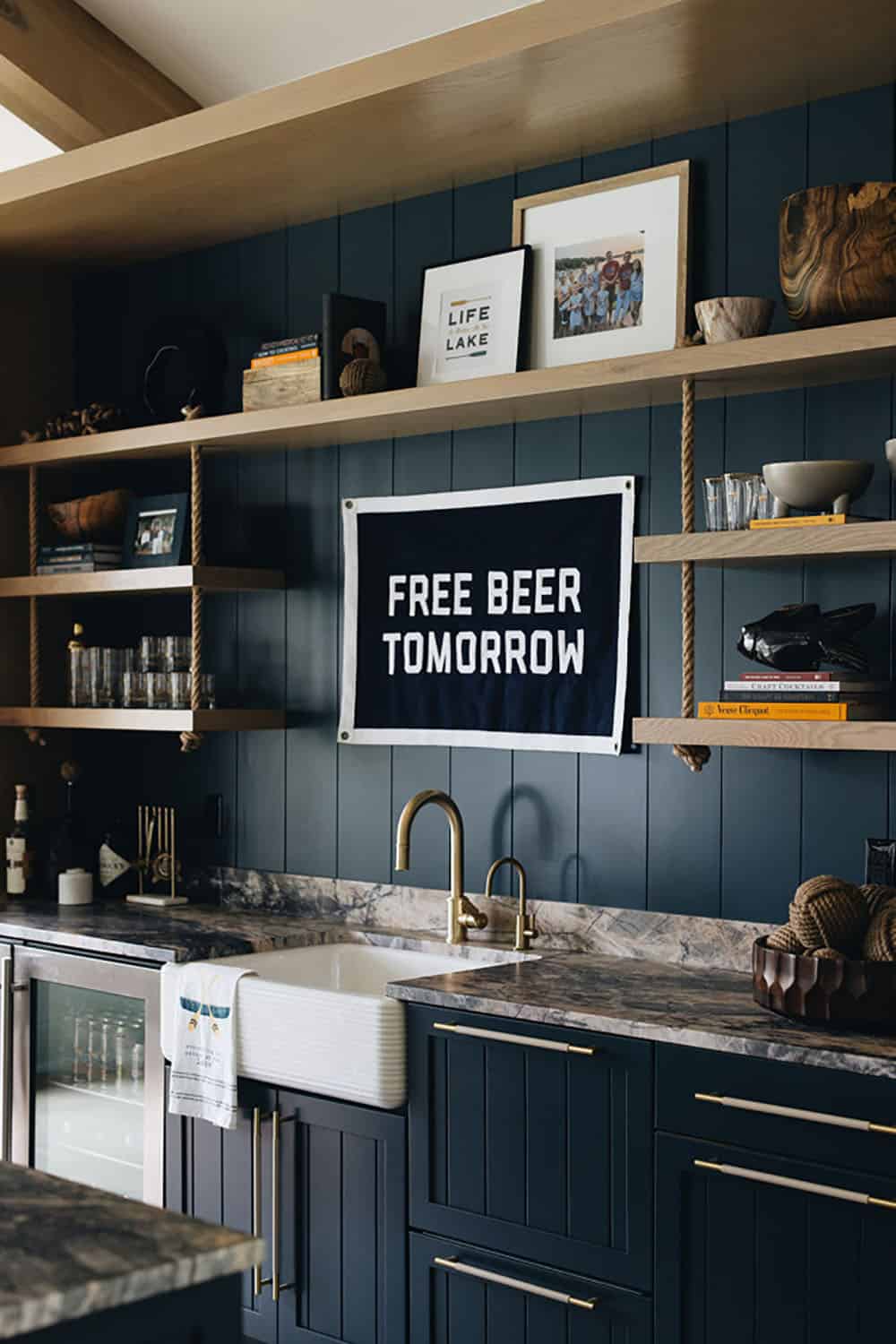 Close-up of navy wet bar shelving with "Free Beer Tomorrow" banner