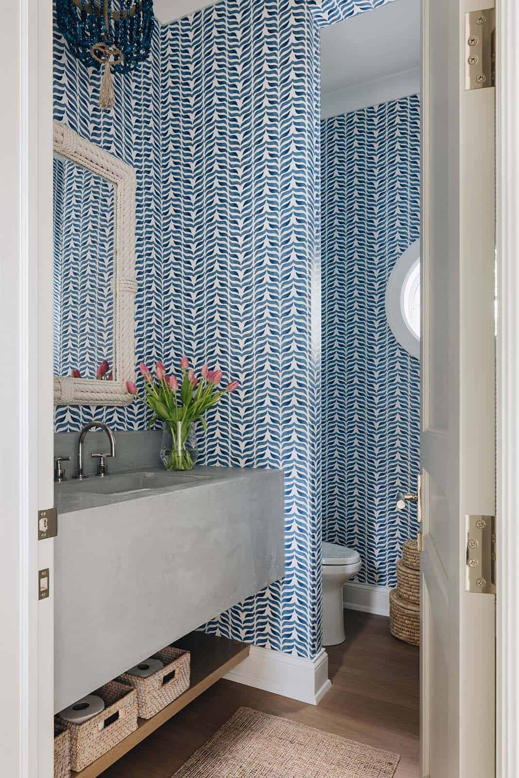 Powder room with blue leaf-print wallpaper and concrete floating vanity