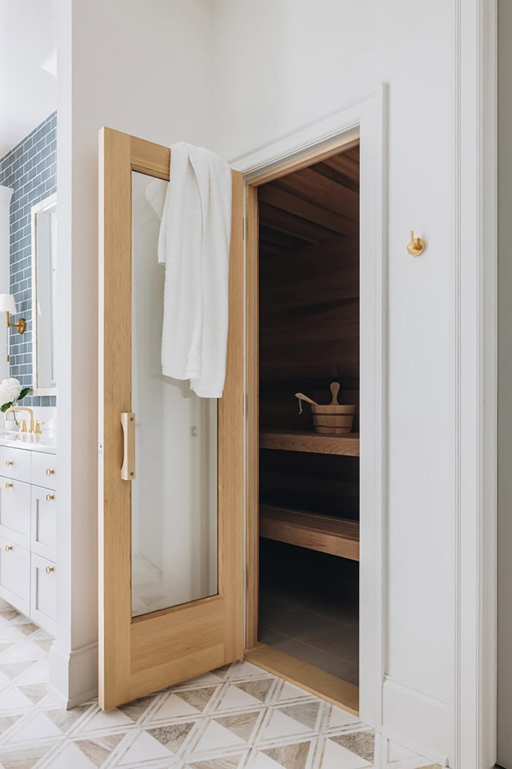 Sauna entrance with glass door, wood interior, and hanging towel