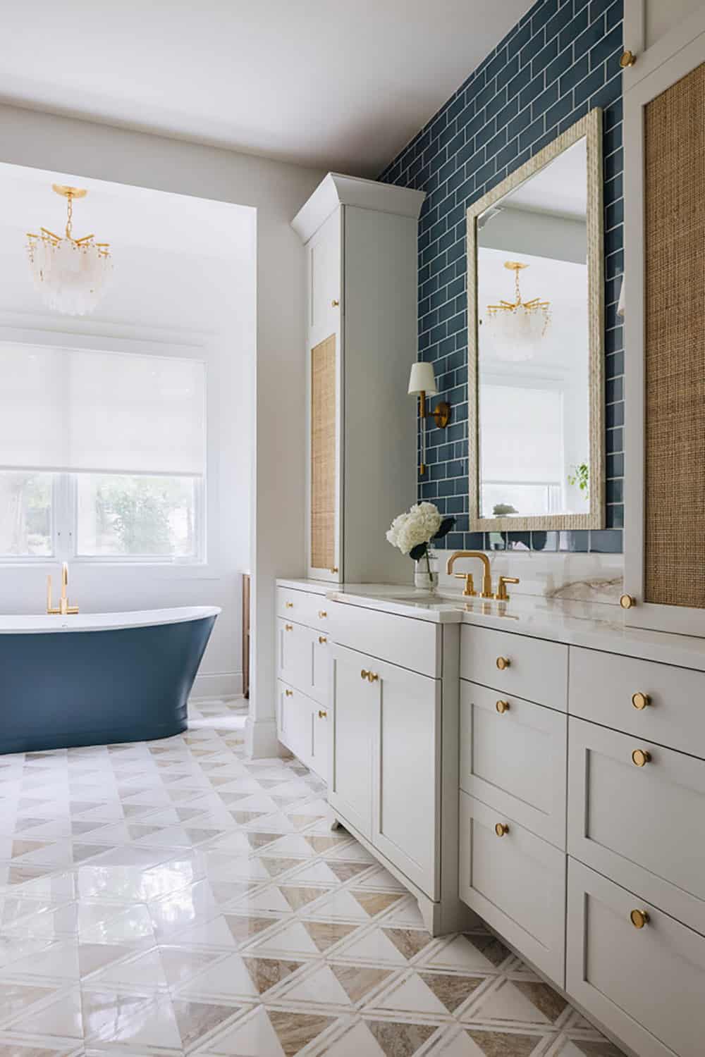 Primary bathroom with navy soaking tub, blue subway tile, and patterned floor