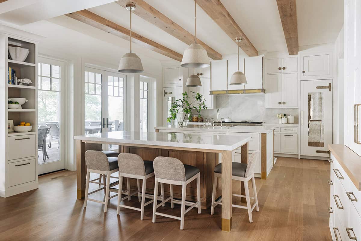 Open kitchen with dual islands, woven pendant lights, and wood beam ceiling