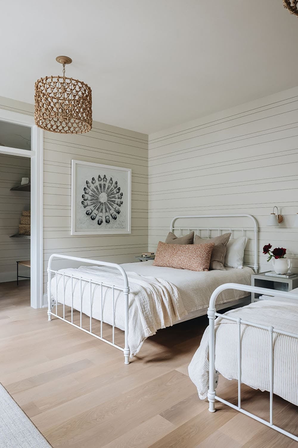 Kids' bedroom with iron beds, round wall art, and shiplap walls