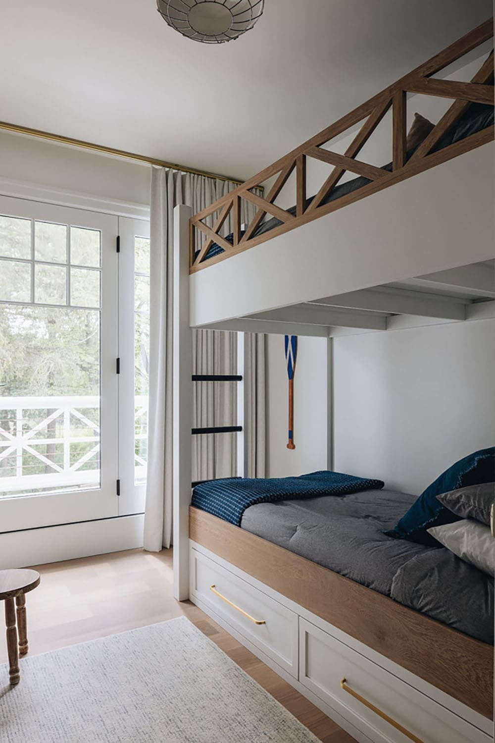 Built-in bunk bed with wood lattice railing and hanging oar decor