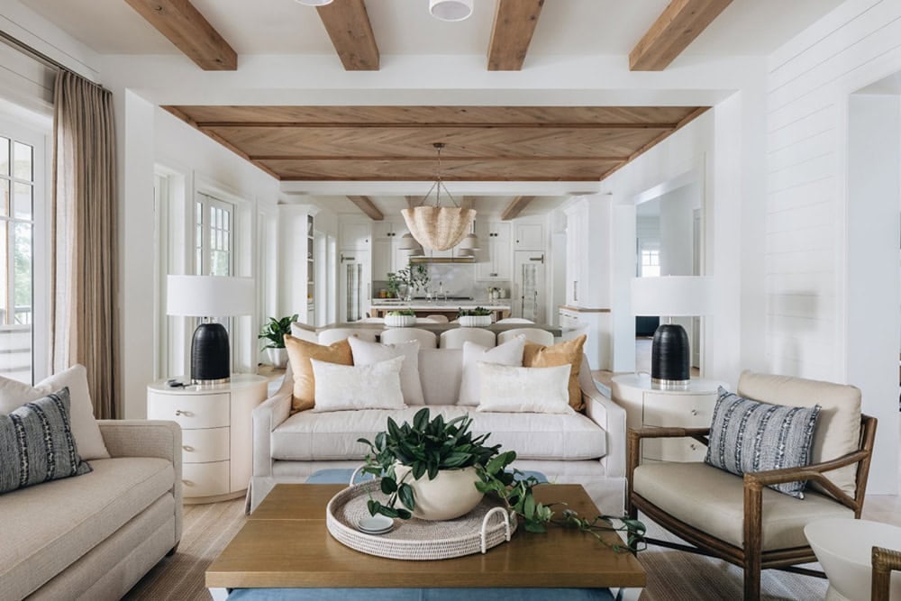 Living room with neutral sofas opening into dining room and kitchen beyond