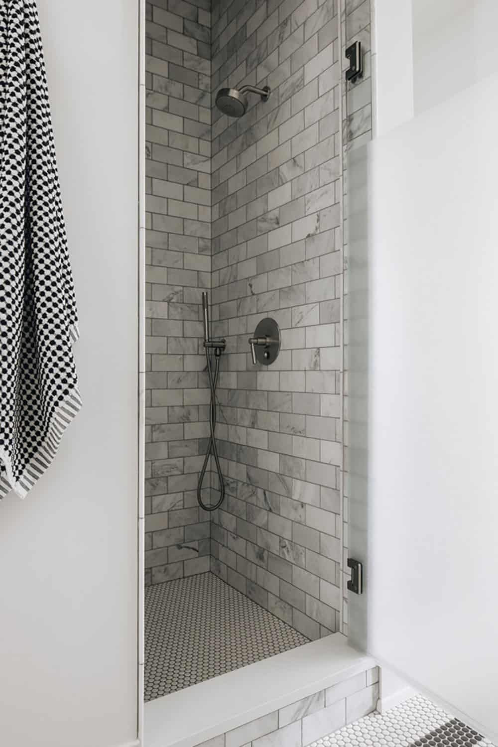 Walk-in shower with marble subway tile and handheld sprayer