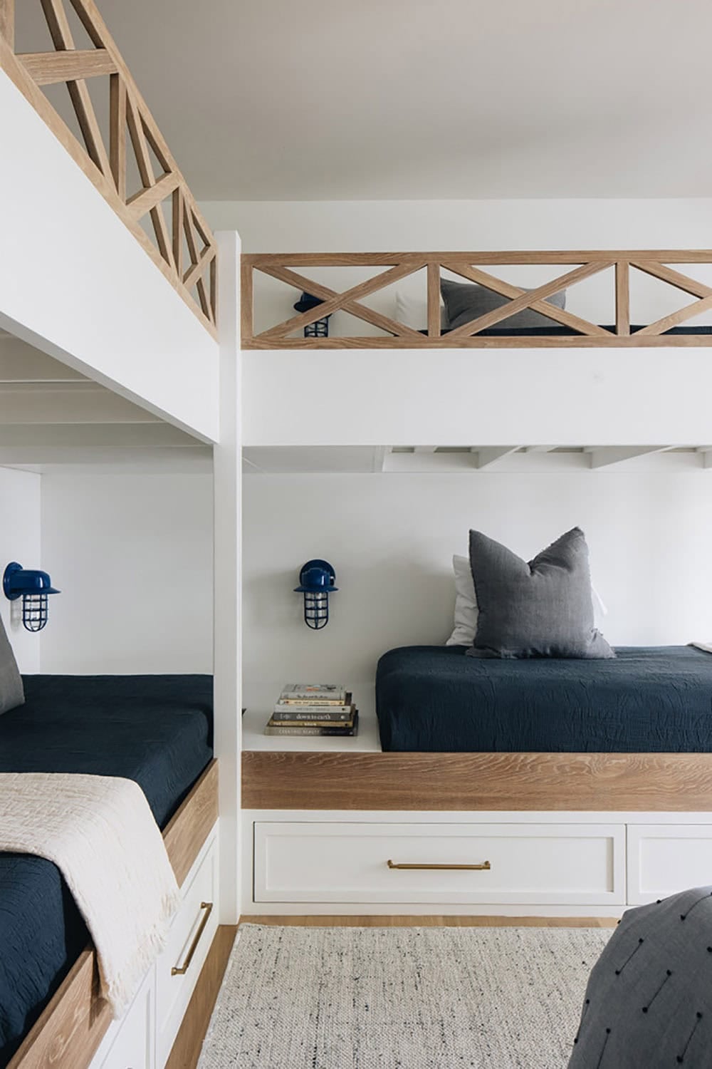 Close-up of built-in bunk beds with wood lattice rails and navy bedding
