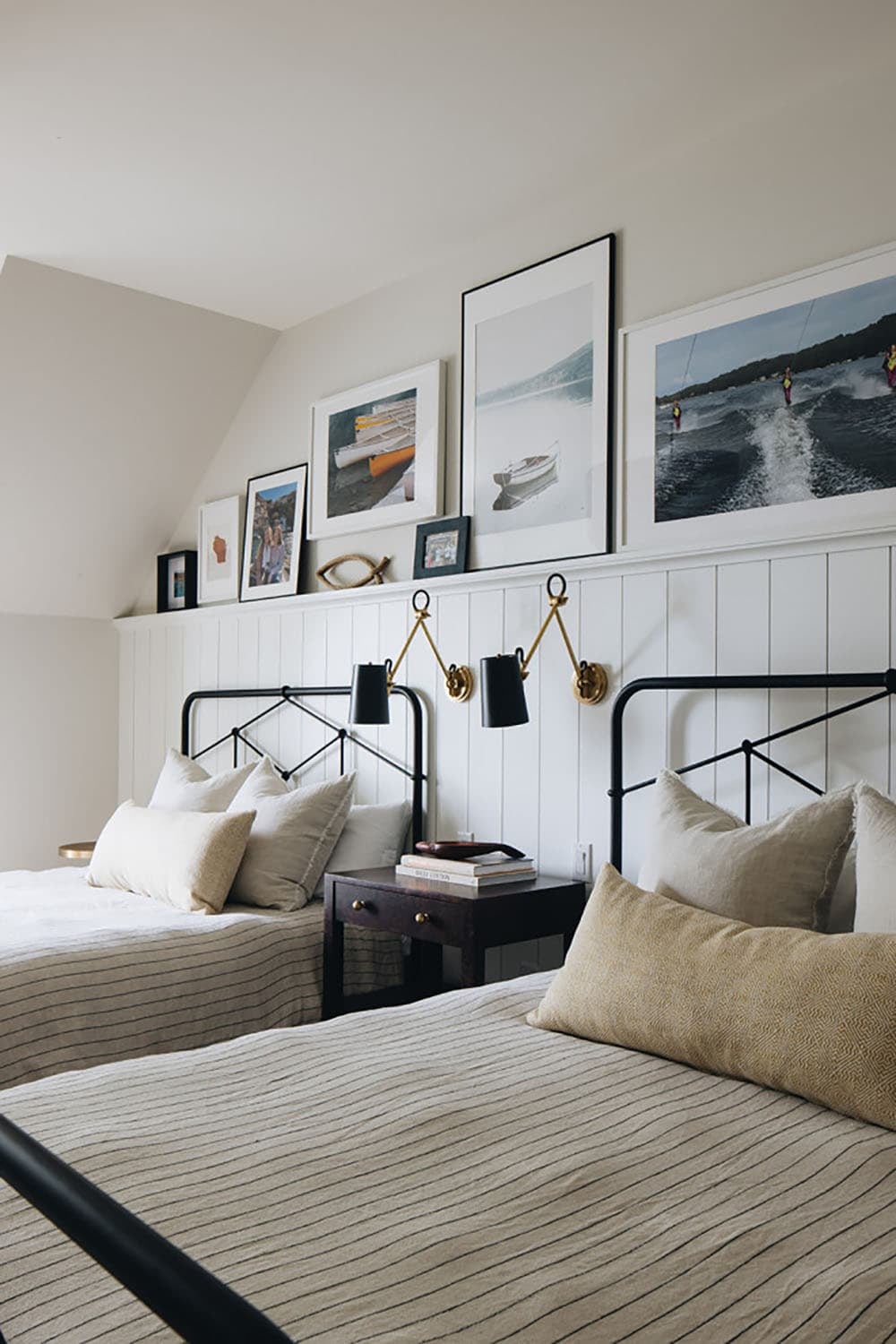 Close-up of twin beds with gallery wall of lake and boating photos