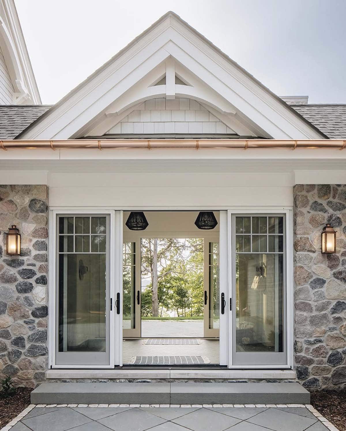 Sliding glass doors opening from porch to lake view with woven pendant lights