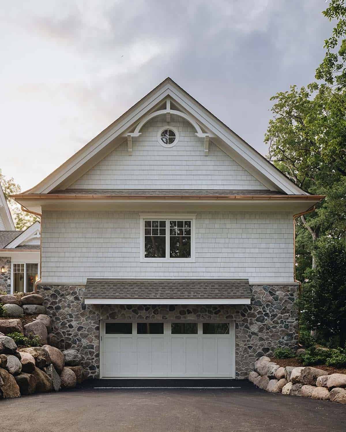 Garage exterior with round window gable and stone-clad base