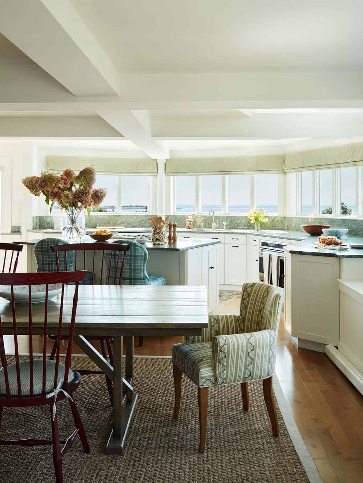 Open kitchen with ocean-view windows and plaid dining chairs