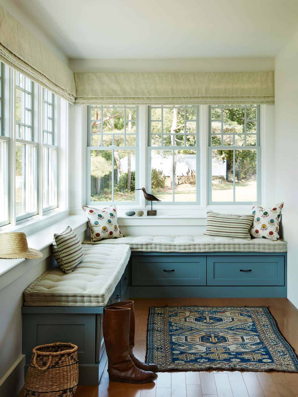 Window seat nook with blue storage bench and kilim rug