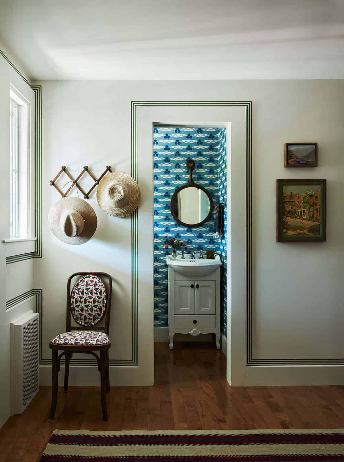 Hallway view into blue wallpapered powder room