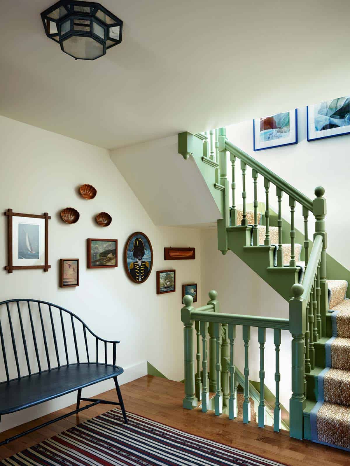 Staircase landing with nautical gallery wall and windsor bench