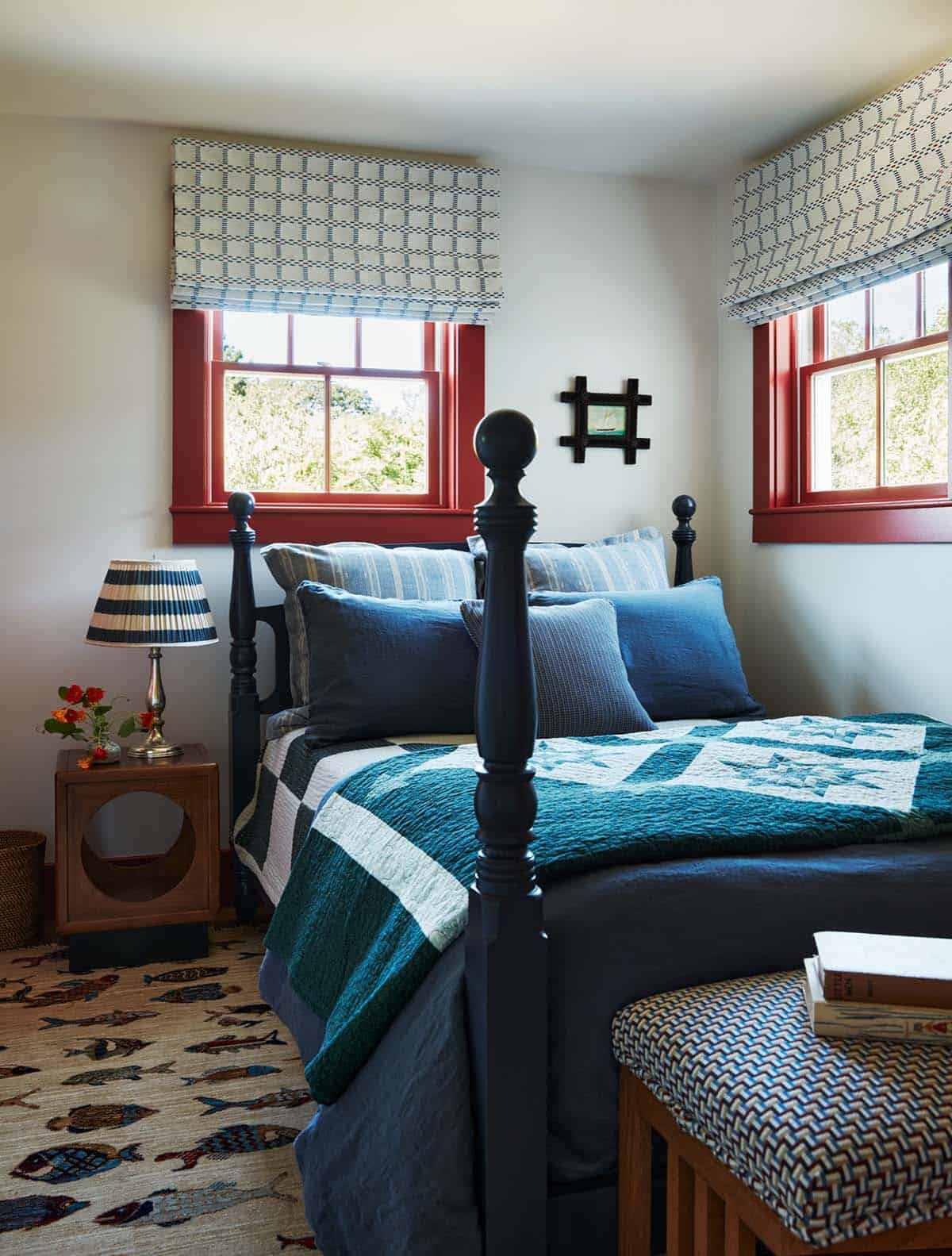 Guest bedroom with red-trimmed windows and navy quilted bedding