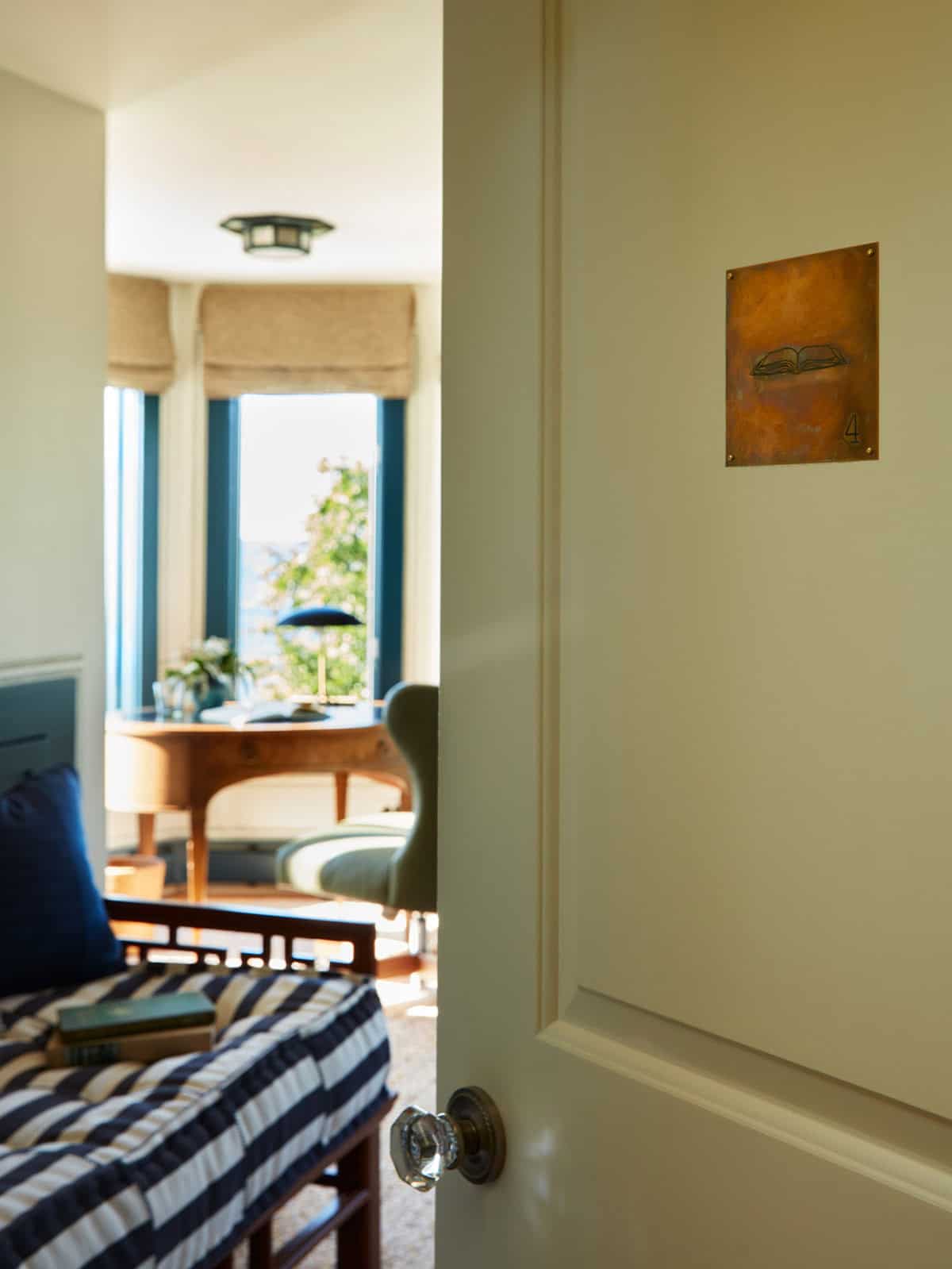 Hallway view into ocean-view office with room number plaque