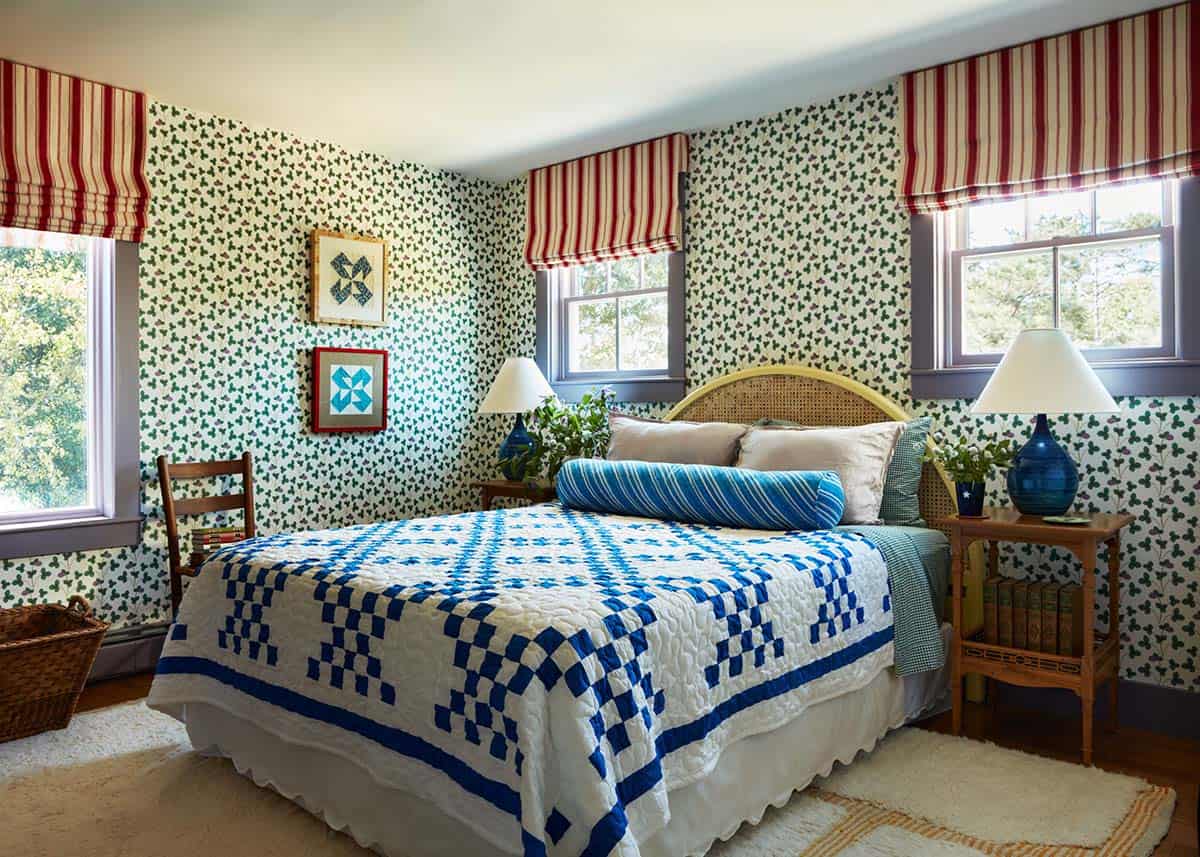 Guest bedroom with clover print wallpaper and blue quilt