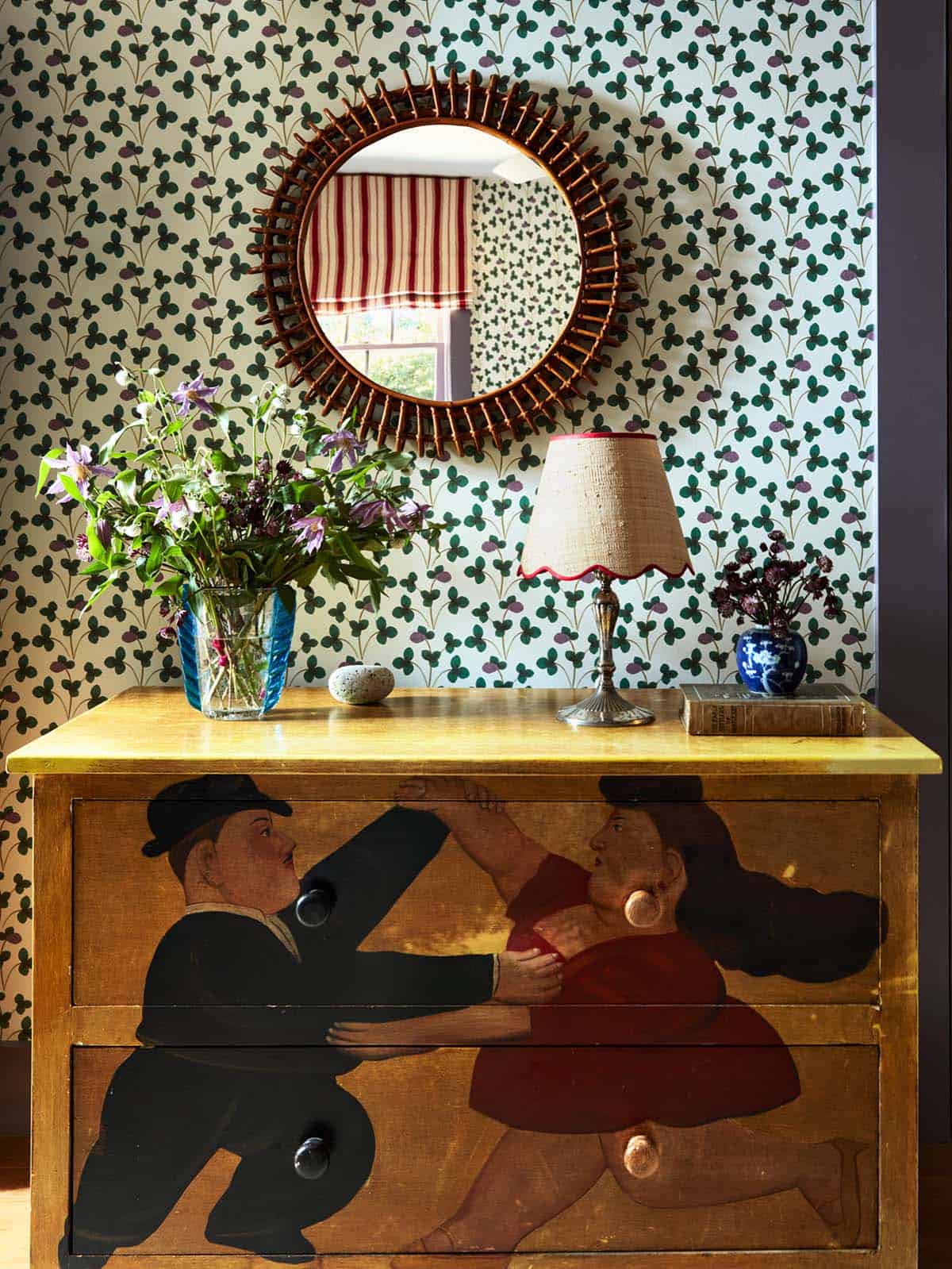 Painted dresser with clover wallpaper and rattan sunburst mirror