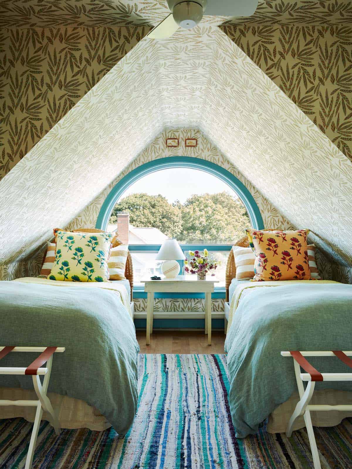 Twin bedroom under eaves with arched window and leaf wallpaper