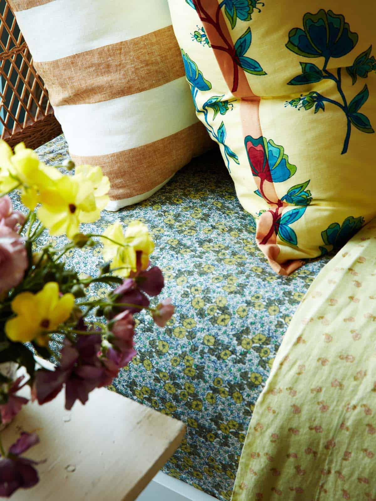Detail of striped and floral throw pillows on bed