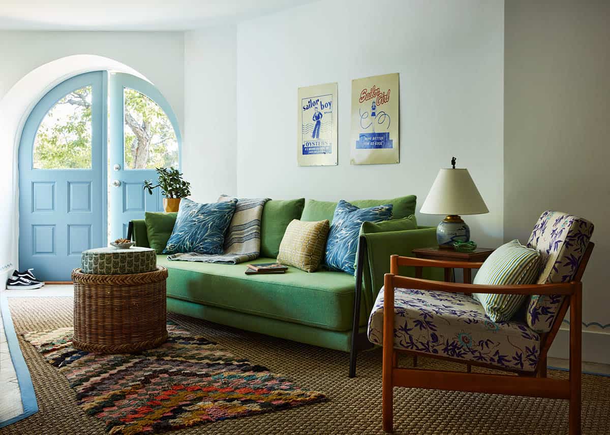Sitting room with green sofa and turquoise arched door