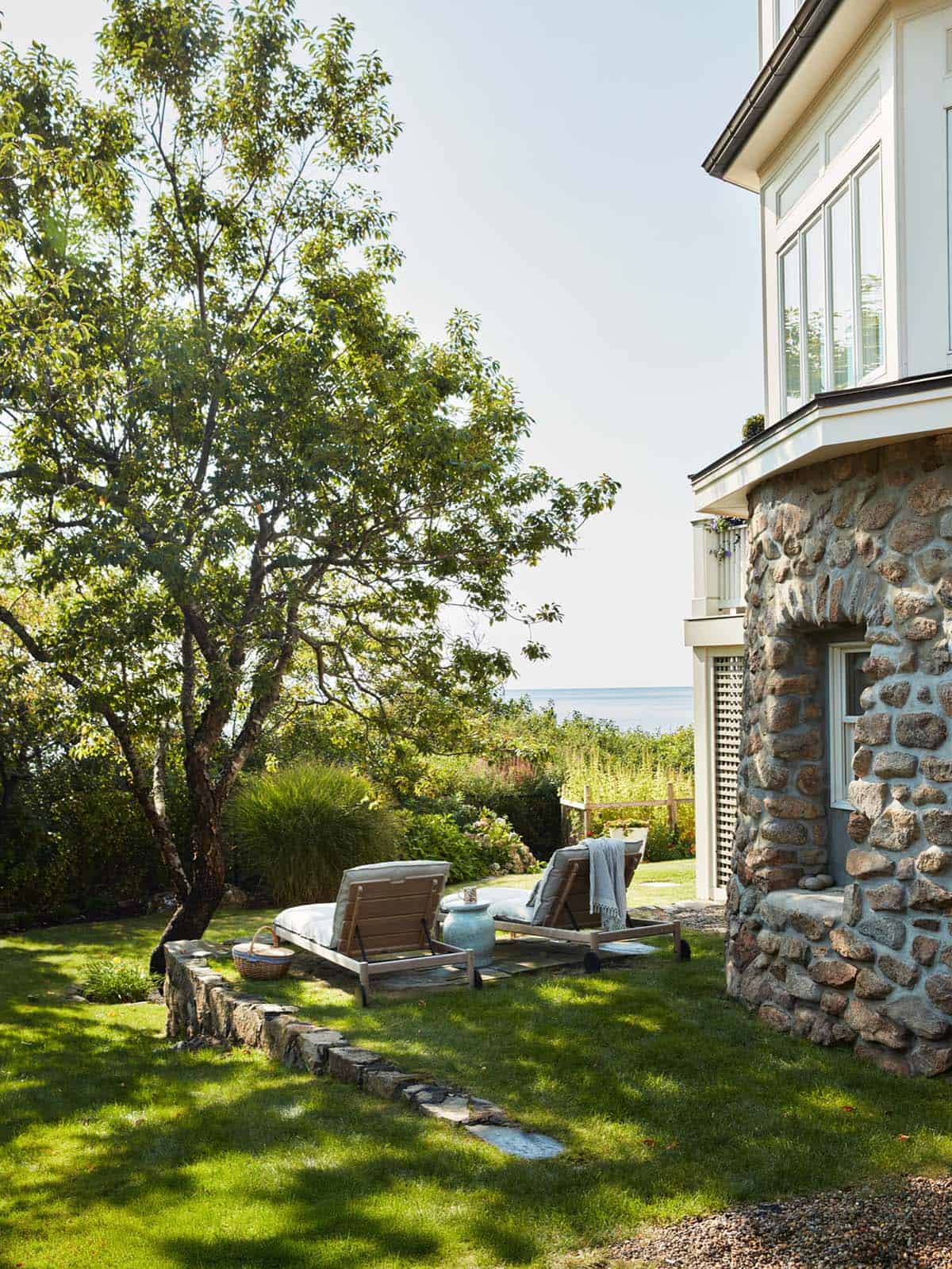 Stone exterior with lawn chaise loungers and ocean view
