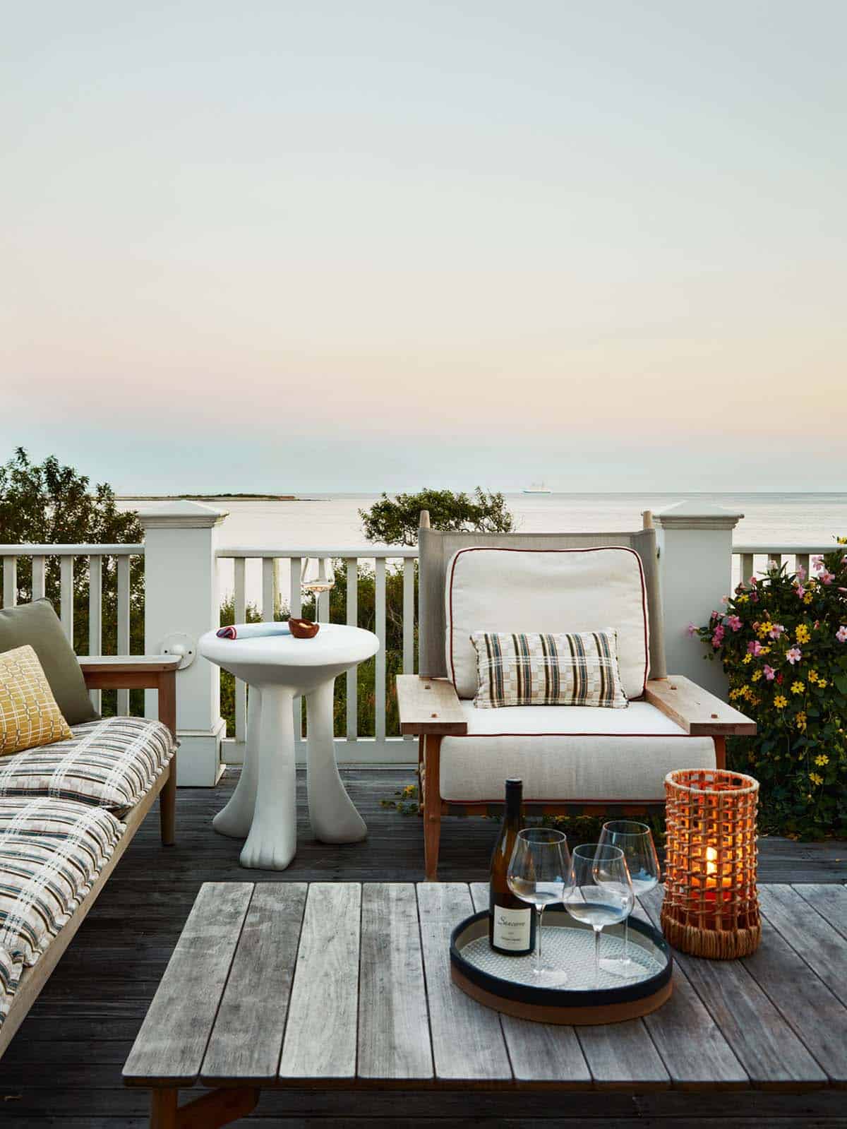 Oceanfront deck seating at dusk with wine and candlelight