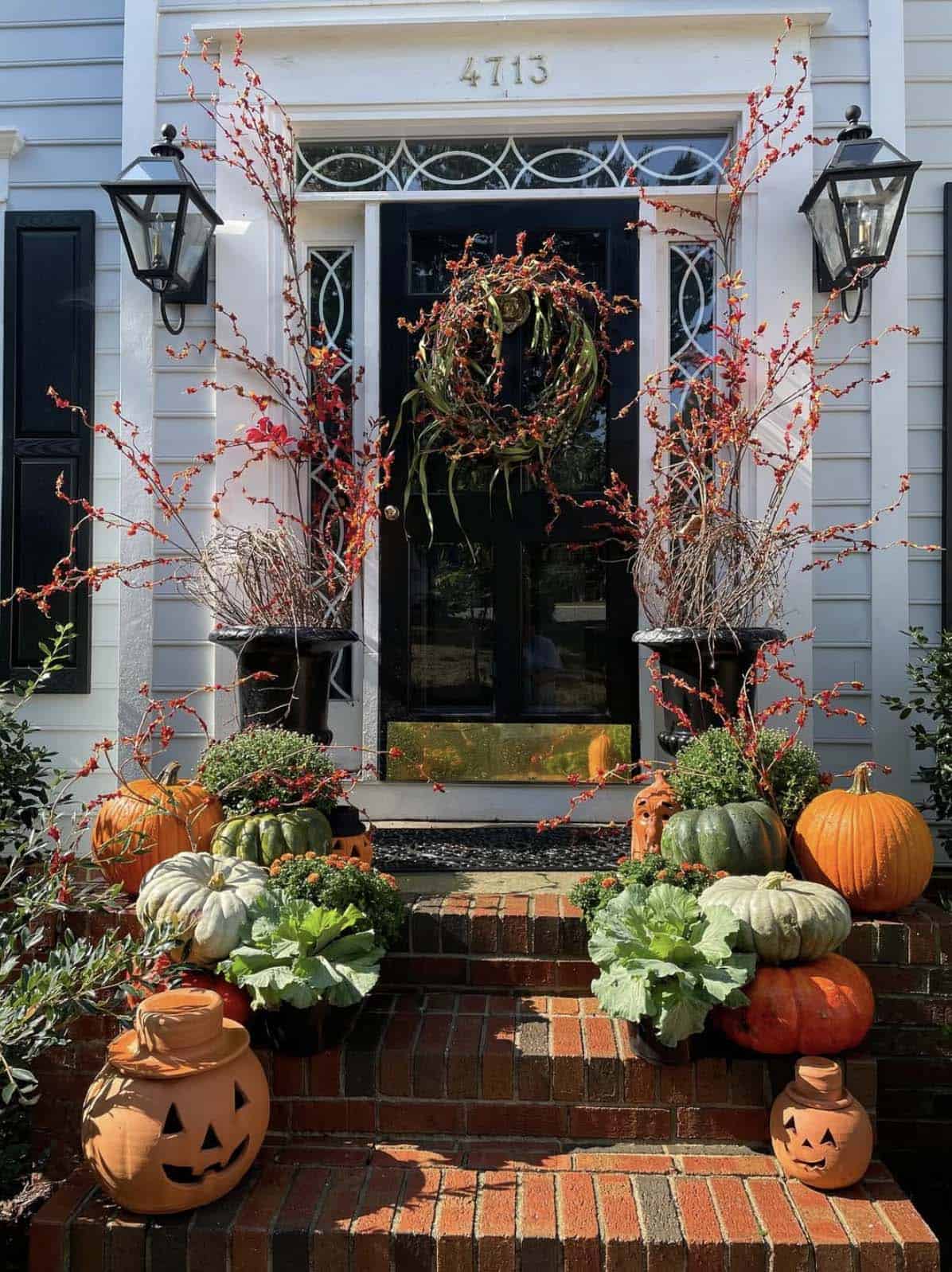 Brick front steps with jack-o'-lantern jars, pumpkins and ornamental cabbage