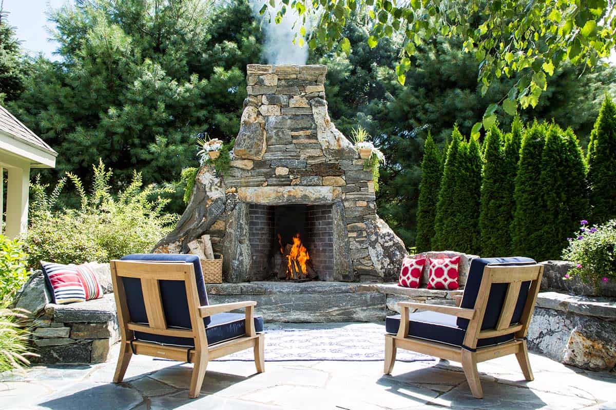 Rustic stone fireplace with organic shape on a wooded patio