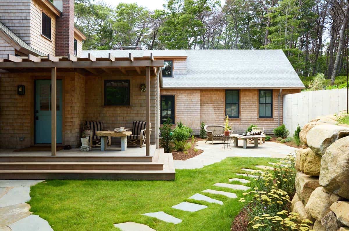 Shingle-style home exterior with pergola deck and stone garden path