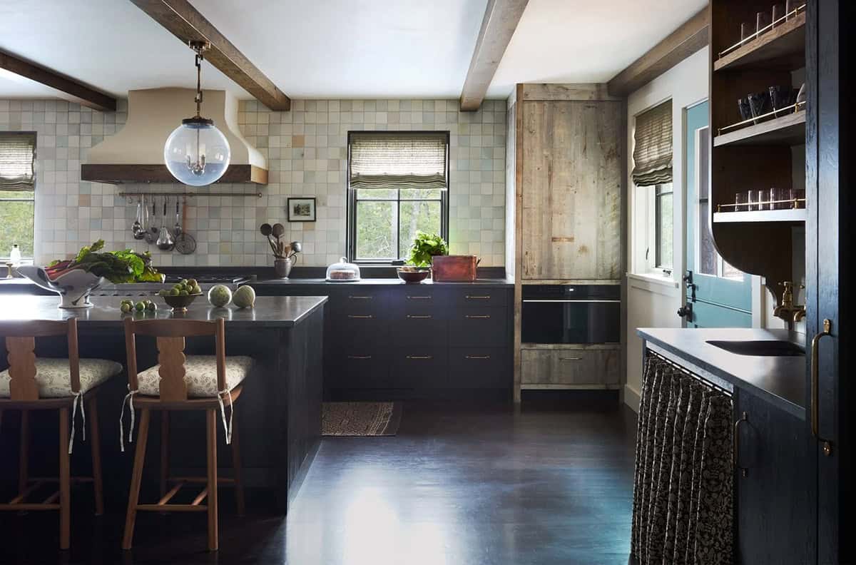 Kitchen with tiled hood, dark cabinetry, and reclaimed wood pantry