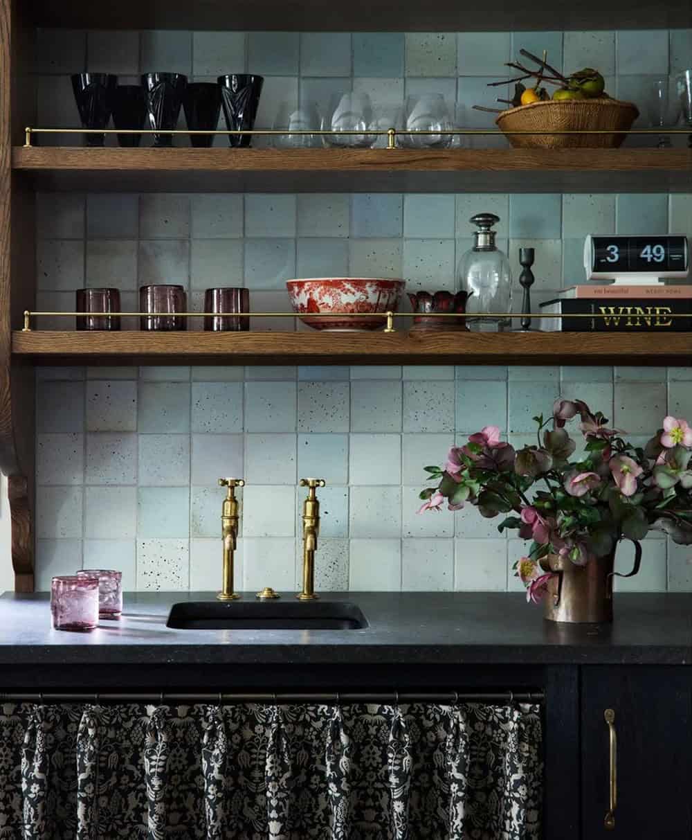 Kitchen shelving with brass rails, glassware, and fresh floral arrangement