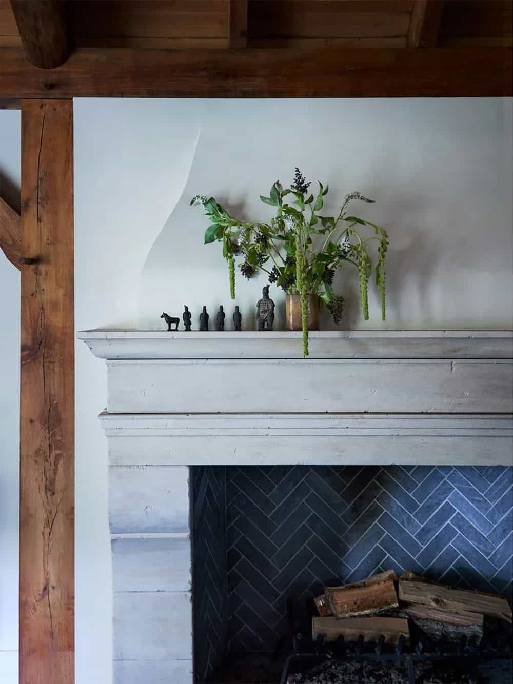 Stone mantel with herringbone tile firebox and terracotta warrior figurines