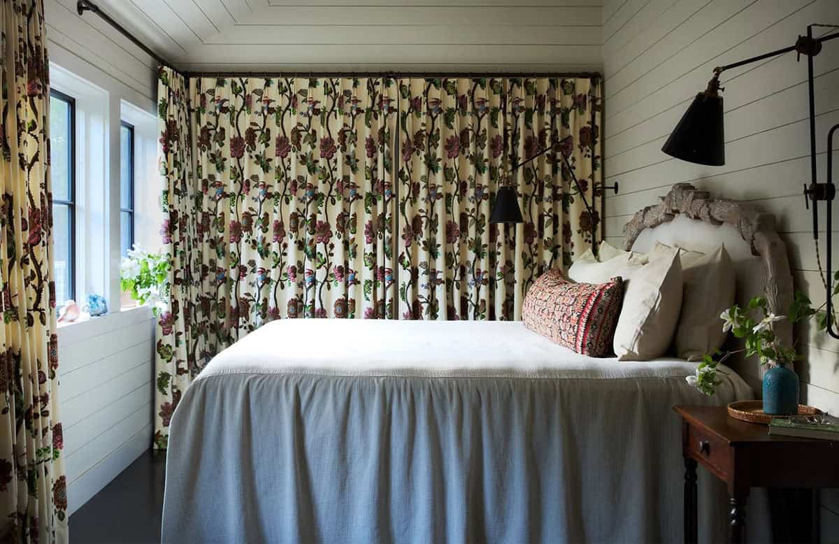 Bedroom with floral drapery backdrop and carved wood headboard