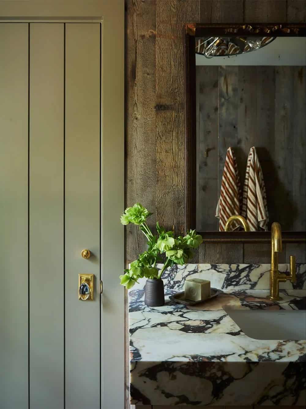 Bathroom vanity with marble countertop and reclaimed wood paneling