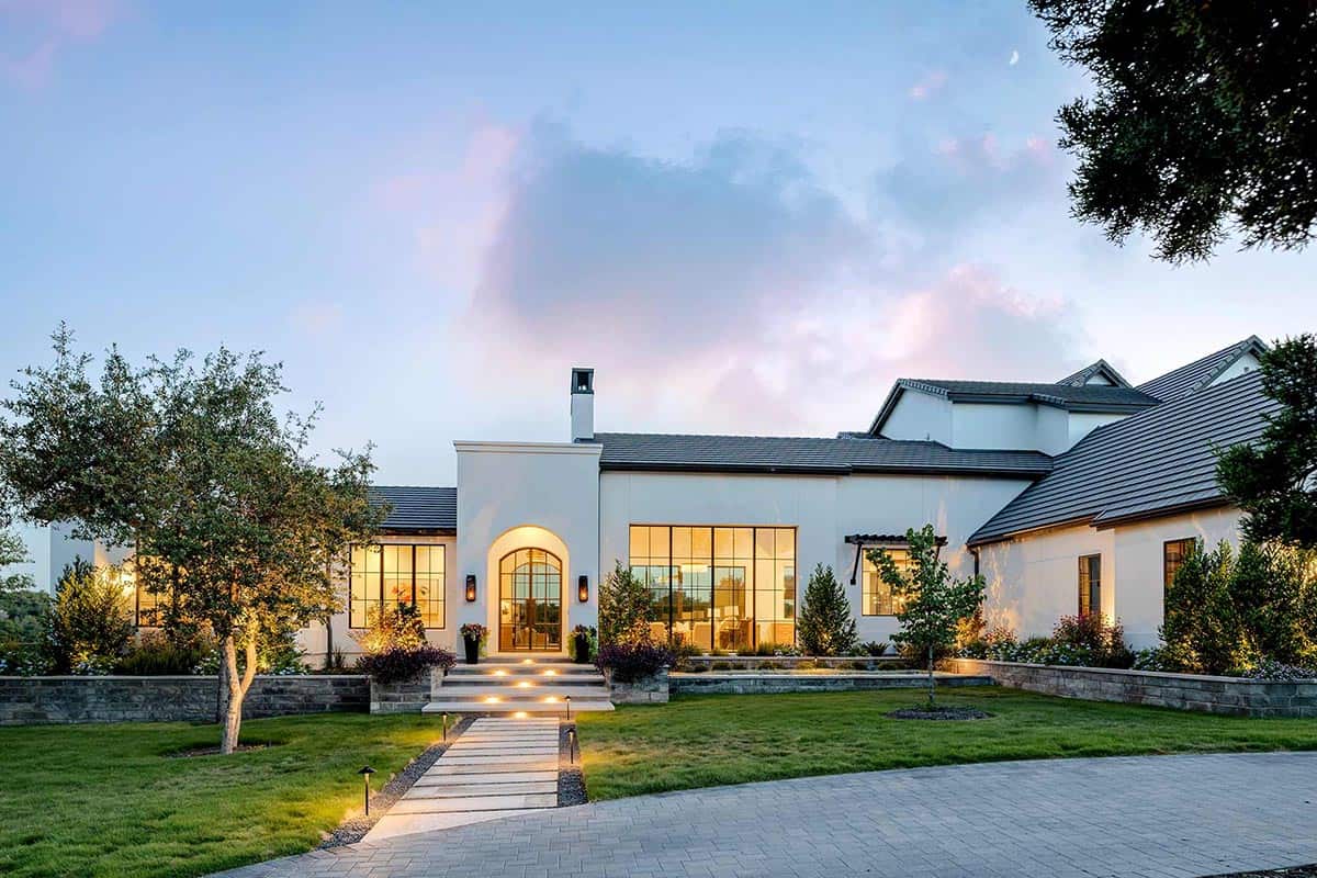 Twilight view of arched entry and steel framed windows