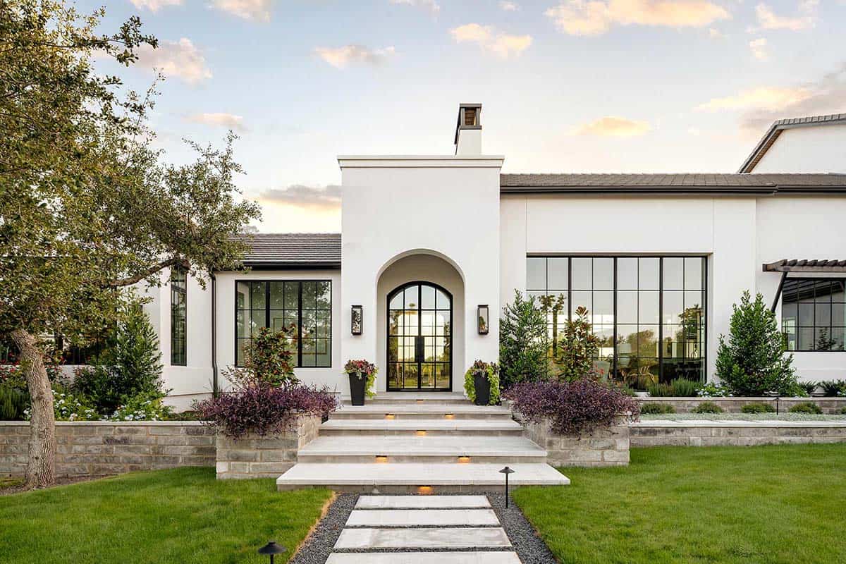 Front entry with arched steel door and stone steps