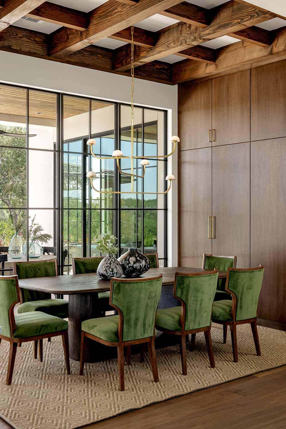 Dining nook with green velvet chairs and wood beam ceiling