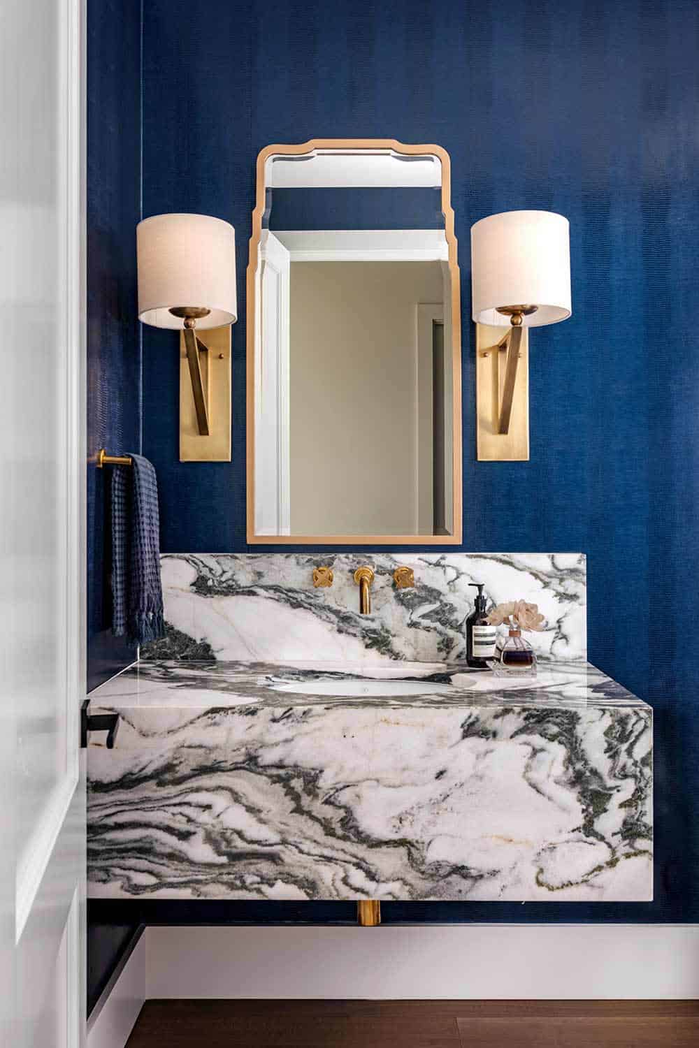 Powder room with veined marble vanity and navy textured walls