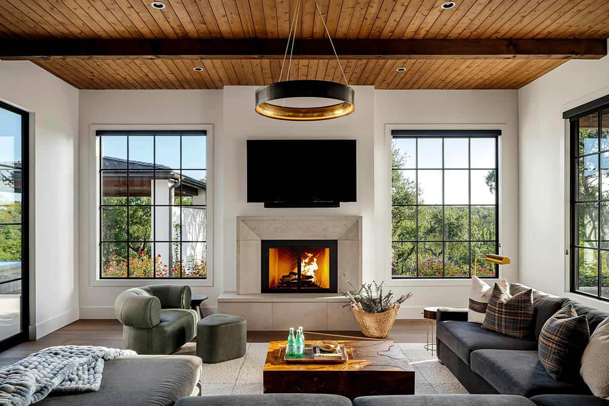 Living room fireplace flanked by black framed windows