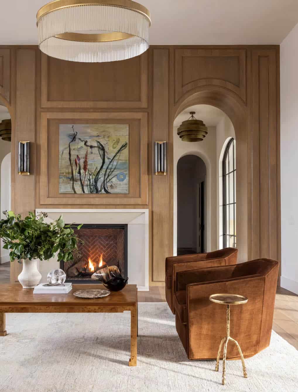 Wood paneled fireplace wall with rust velvet swivel chairs