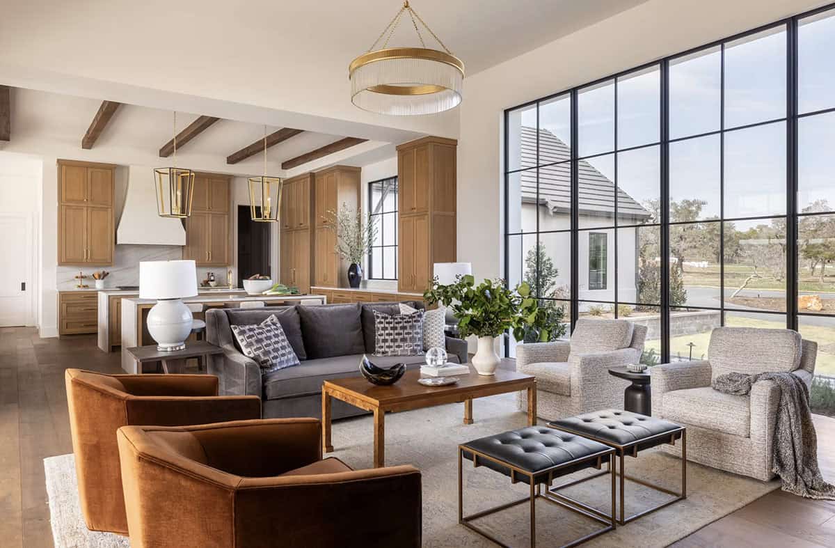 Open living area with brass chandelier and floor to ceiling windows