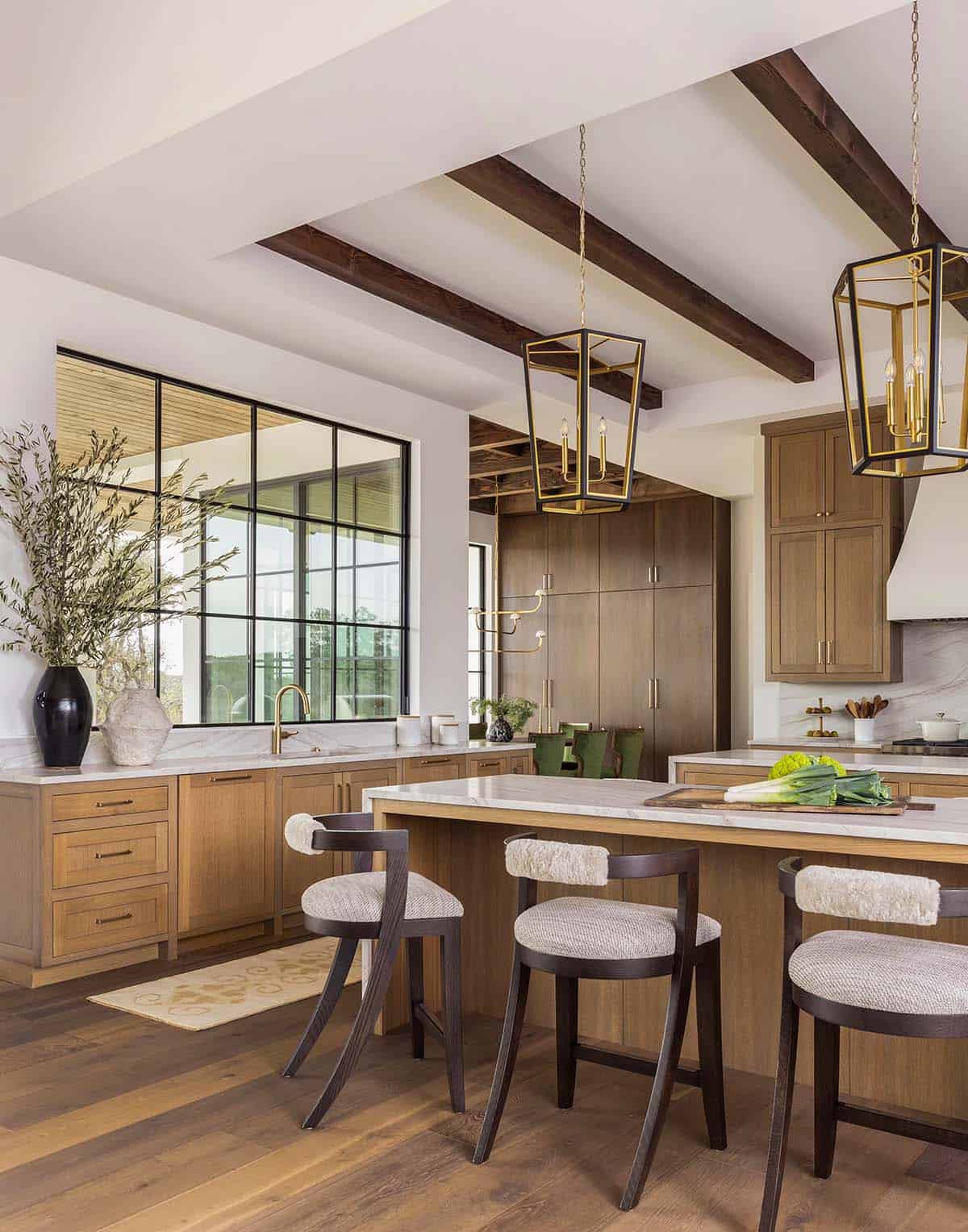 Kitchen island with brass lantern pendants and wood beam ceiling
