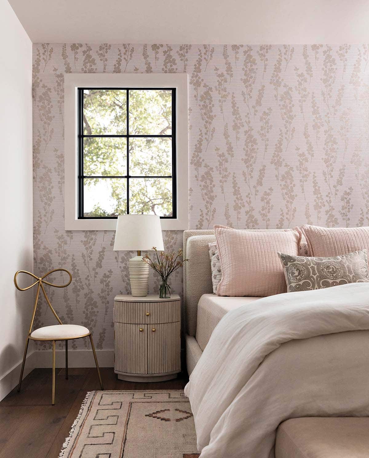 Girls bedroom with floral wallpaper and reeded nightstand