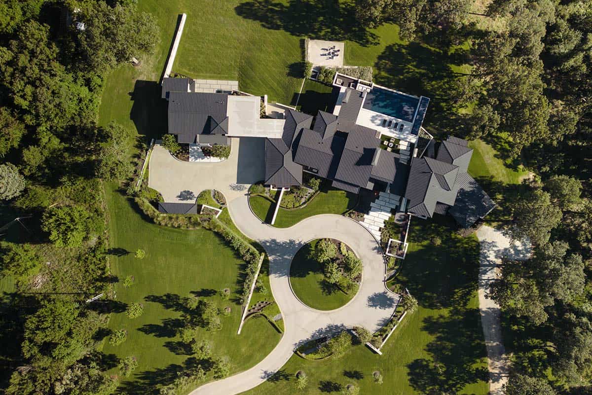 Aerial view of a contemporary home nestled among dense Ozark forest