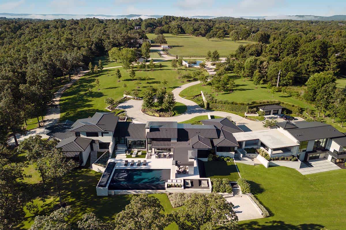 Aerial view of a contemporary home nestled among dense Ozark forest