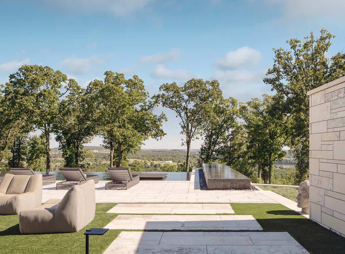 Infinity-edge pool terrace with lounge seating overlooking the Ozark hills