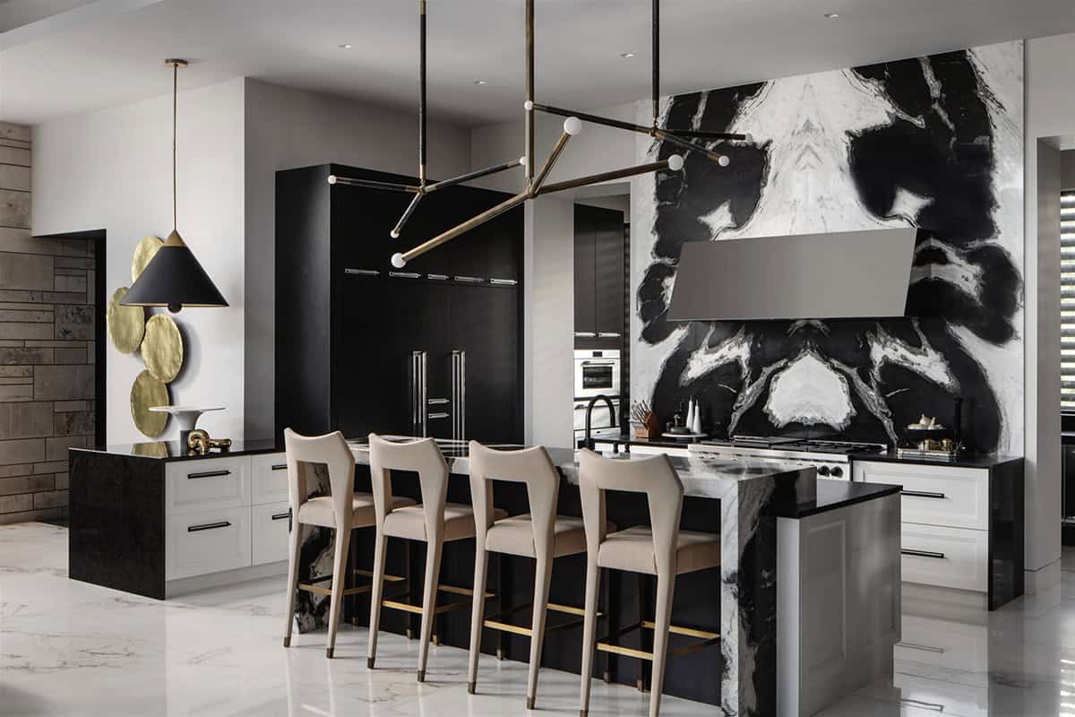 Kitchen island with waterfall marble and dramatic black and white slab wall